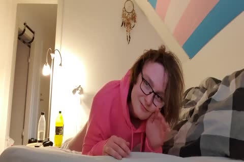 Femboy méchant chevauche un faux pénis tout en portant une vilaine hoodie rose.